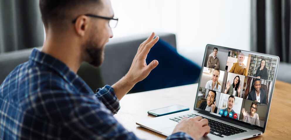 person waving hand and greeting colleagues during video conference