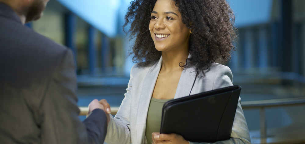 Young female employee greeting supervisor with smile