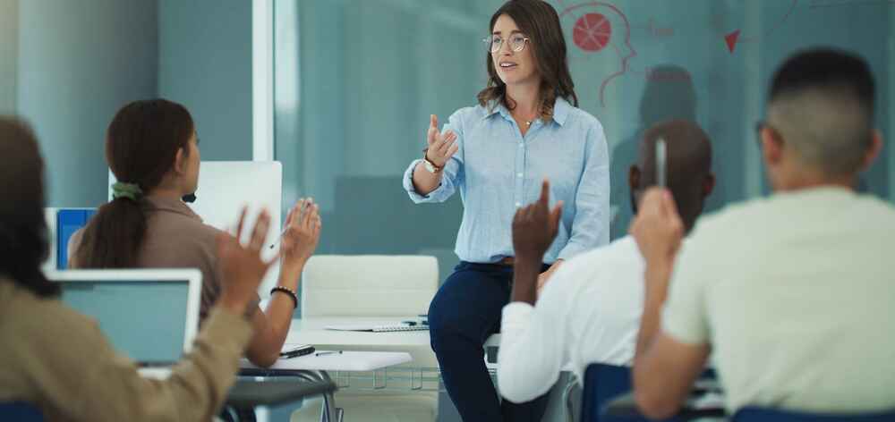 A female professor in a classroom leading a discussion with her students