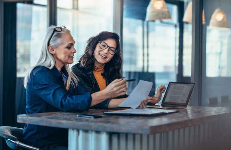 two female professionals working together at a desktop
