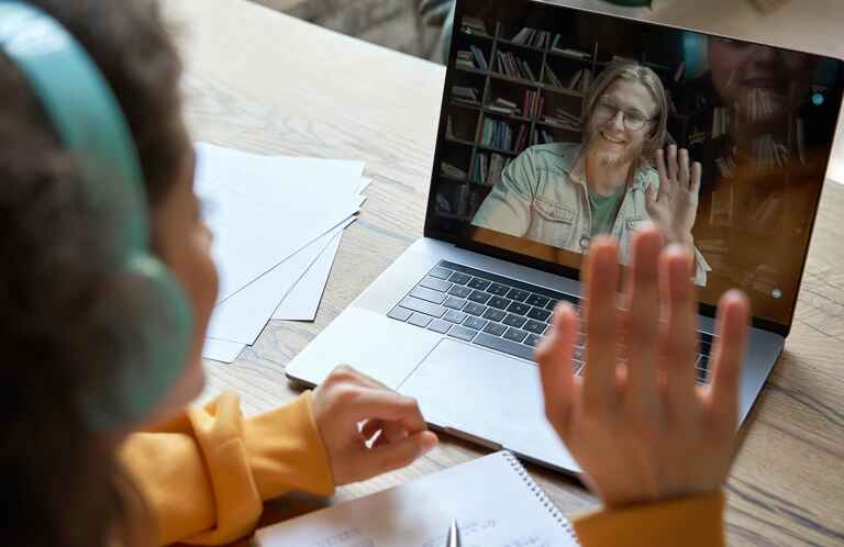 Photo of a female student and male teacher interacting in a virtual meeting