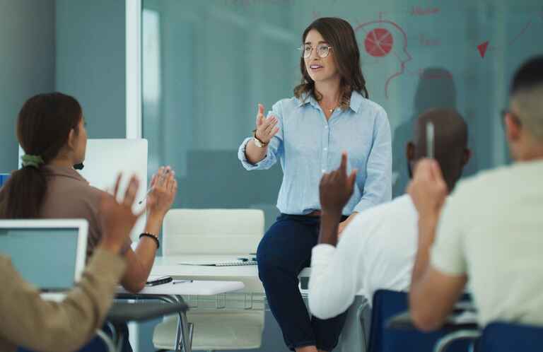 A female professor in a classroom leading a discussion with her students