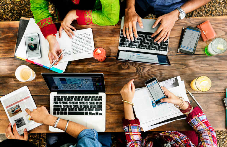 group of people working together using various technology