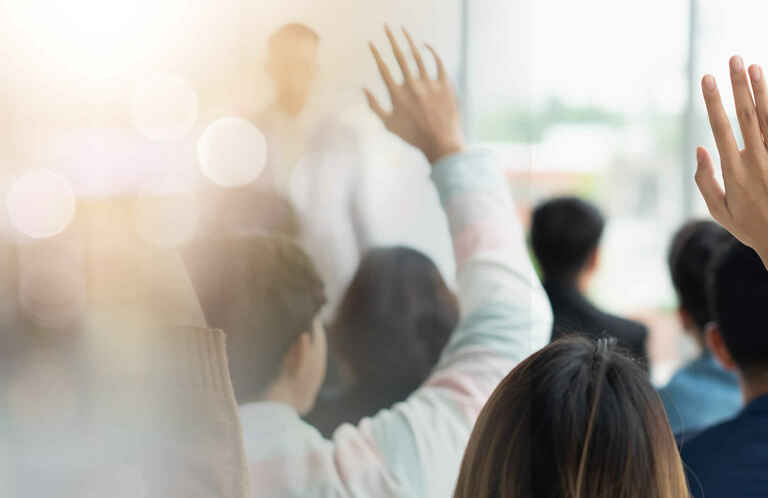 hands raised in a classroom of adult learners
