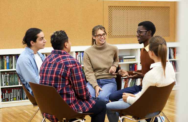 Group of university students sitting in a circle having a group discussion