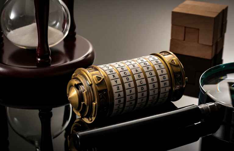 A close-up photograph of a cryptex, an hourglass, and a magnifying glass