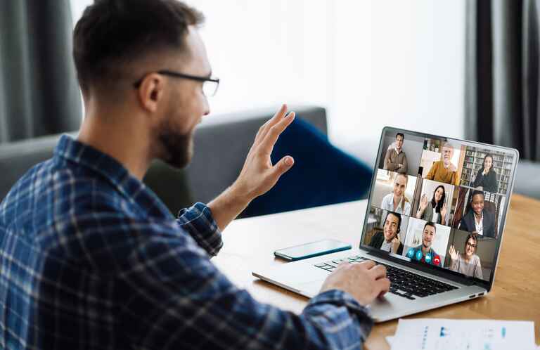 person waving hand and greeting colleagues during video conference