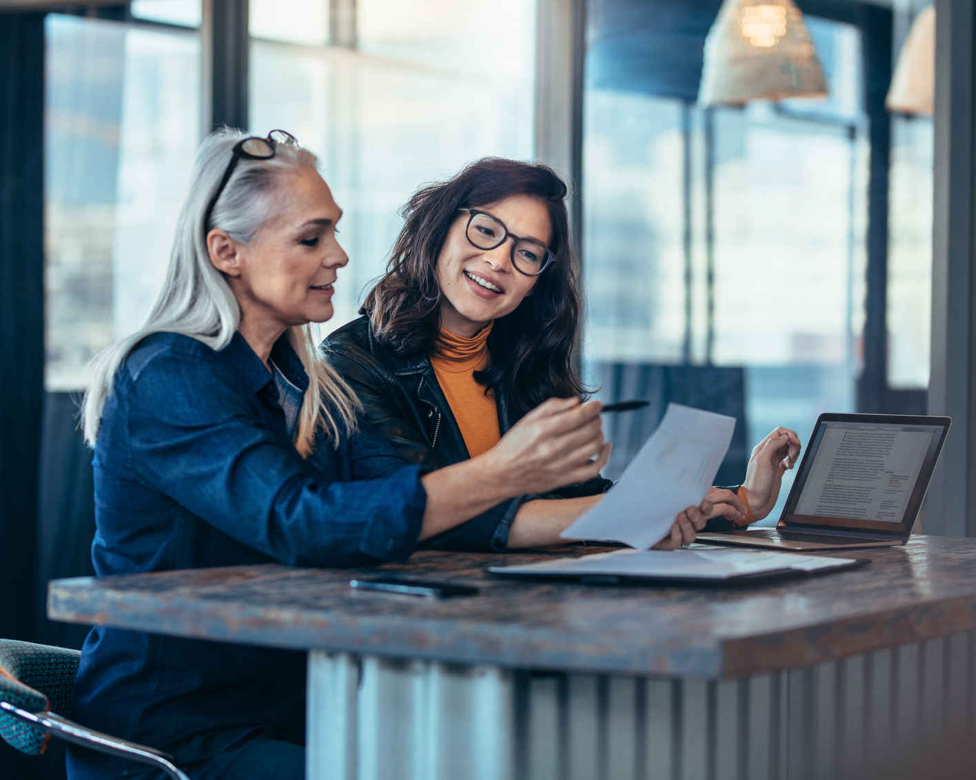 two female professionals working together at a desktop