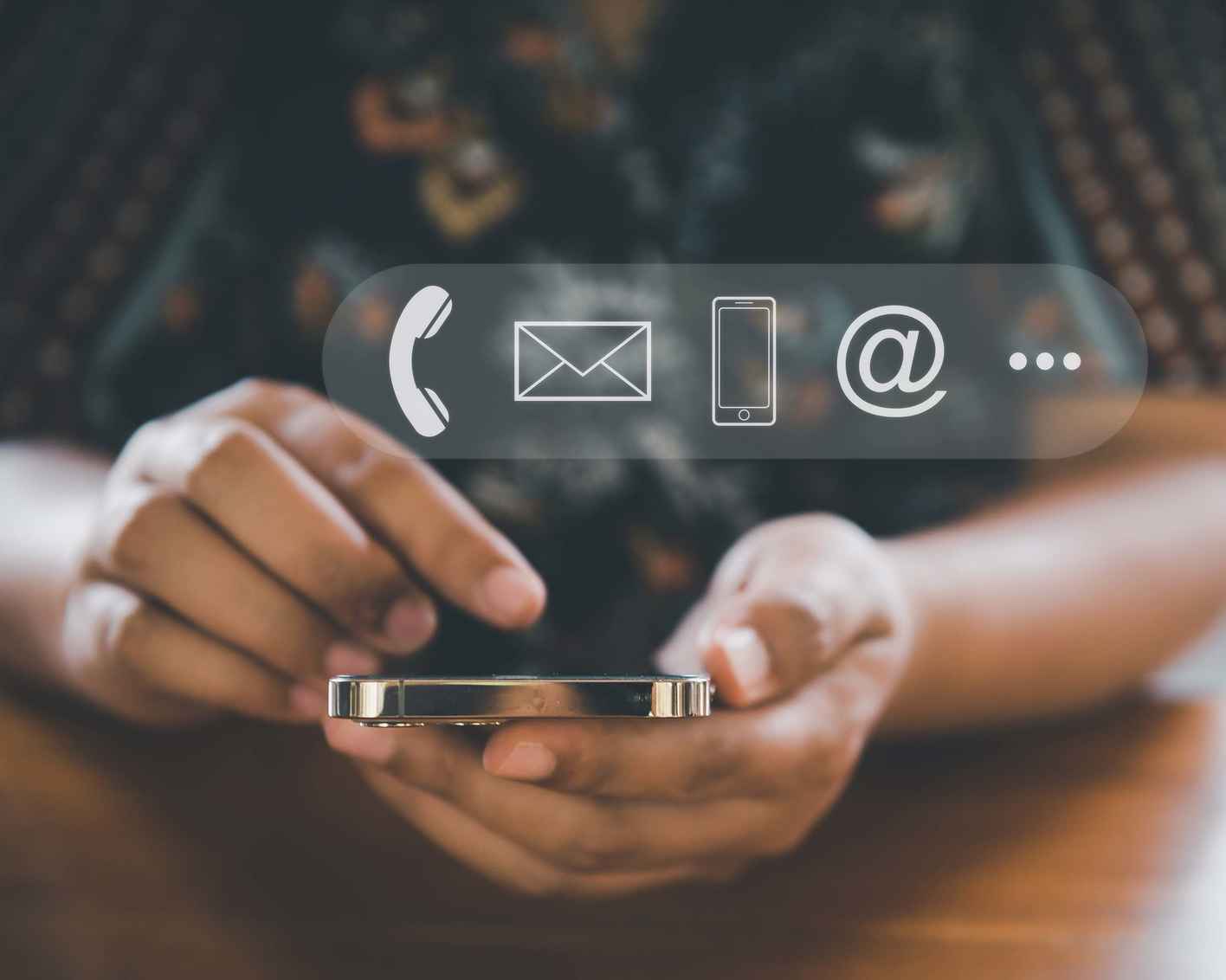 Photo of a woman using her mobile phone with icons for phone, email, etcetera overlayed