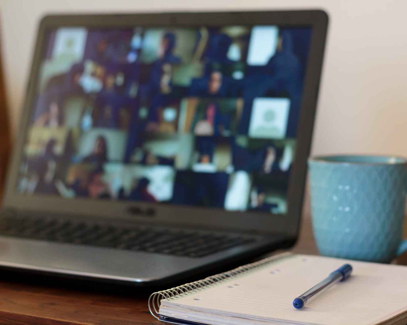 Photo of a laptop computer open, with Zoom attendees on the screen
