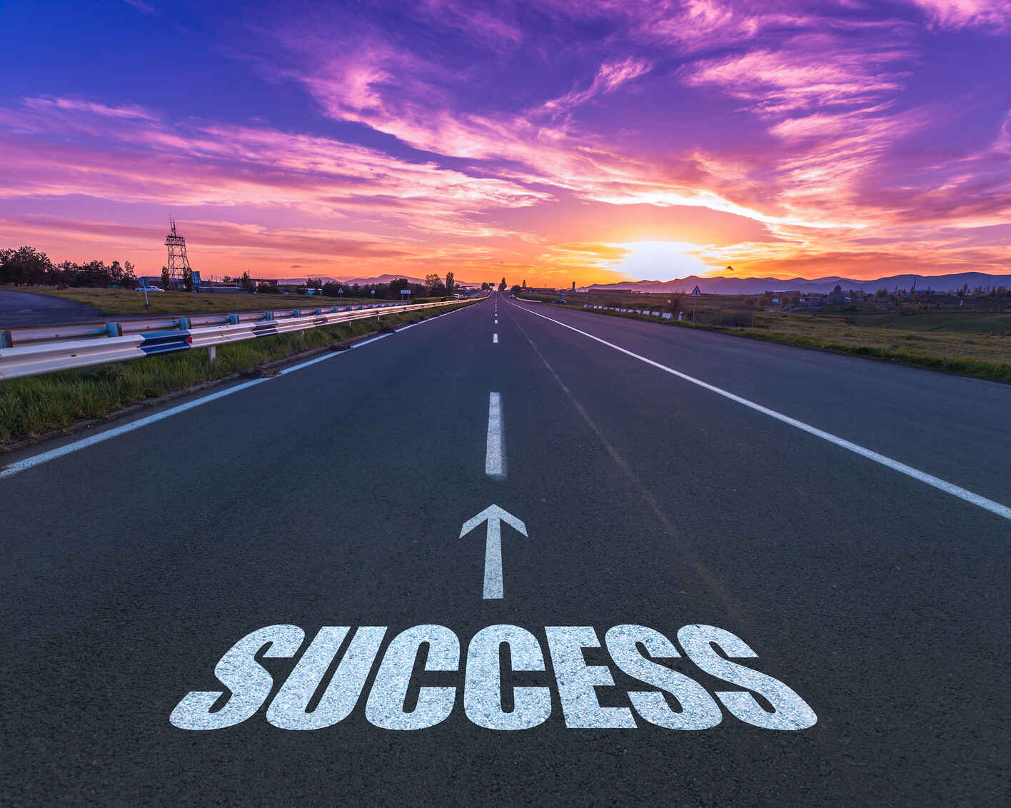 Success written on a road facing the sunset