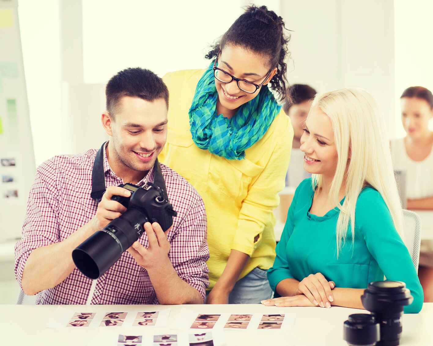 Photo of a smiling team with a camera working in an office