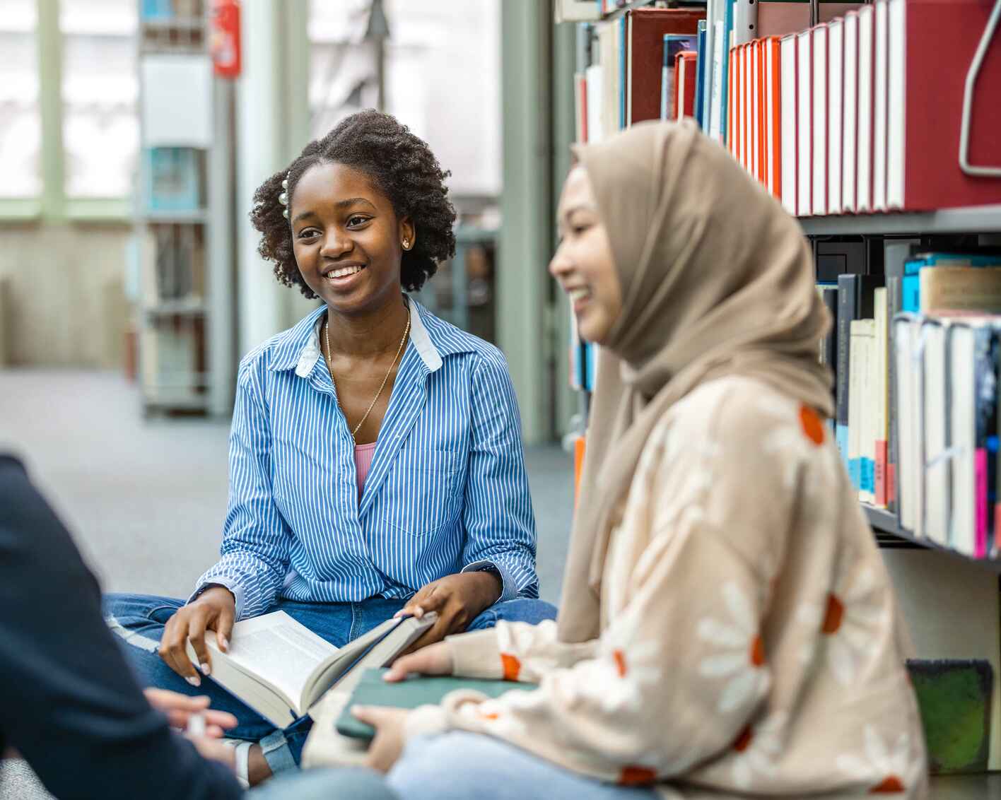 Group of students sitting in a library and studying together