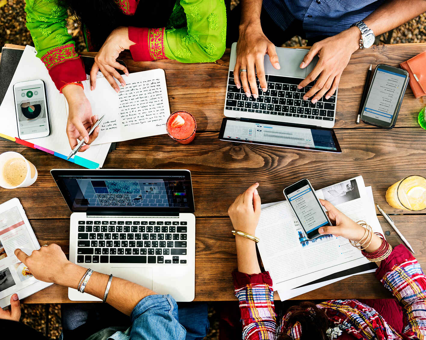 group of people working together using various technology