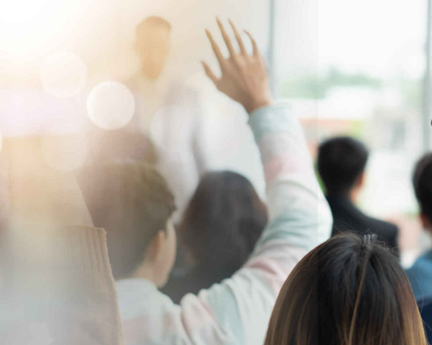 hands raised in a classroom of adult learners