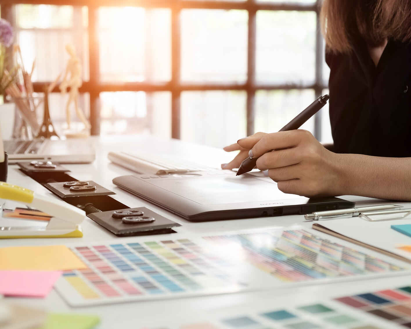 a view of a graphic designer using a wacom tablet and color pallets to design