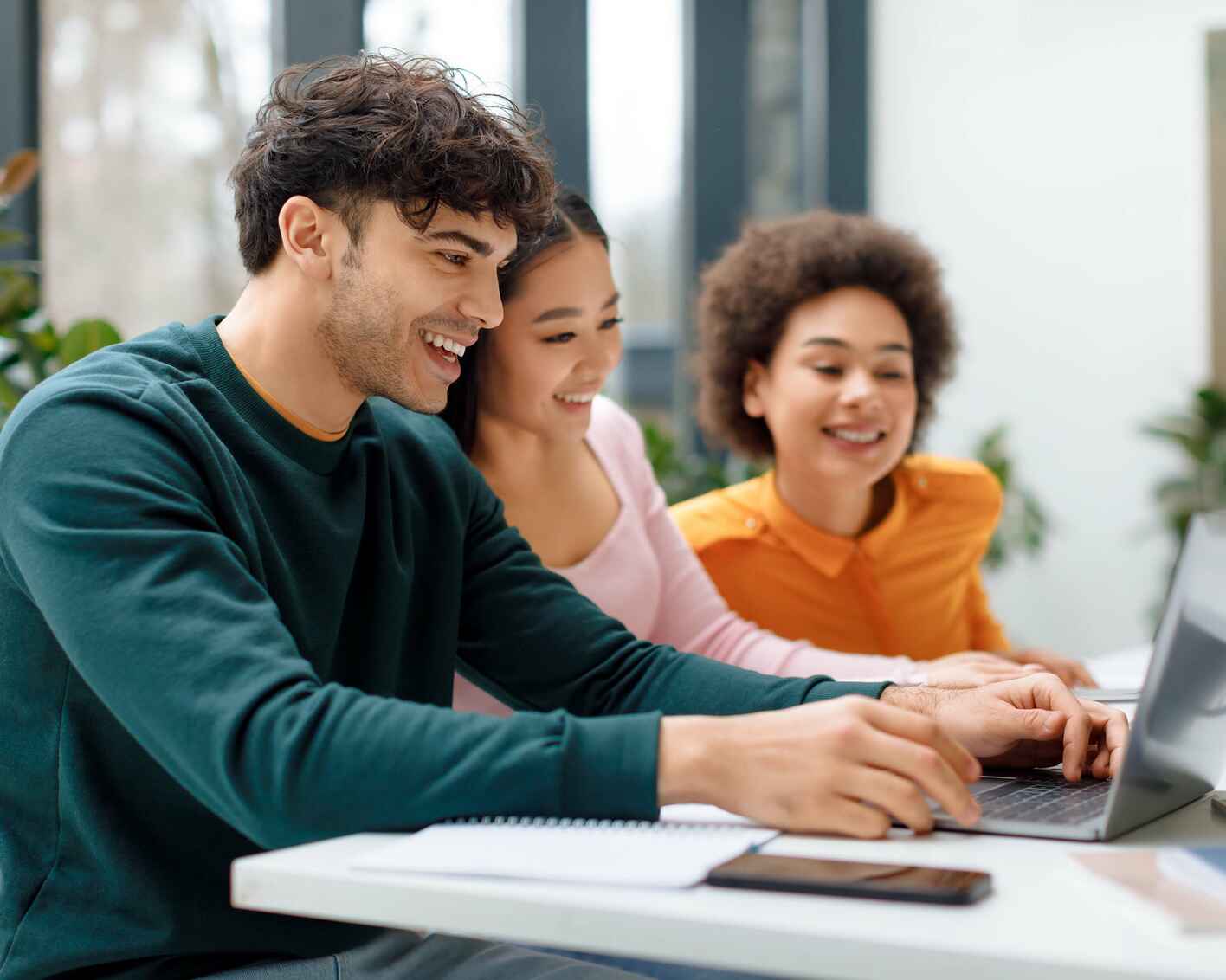 Three people looking at laptop