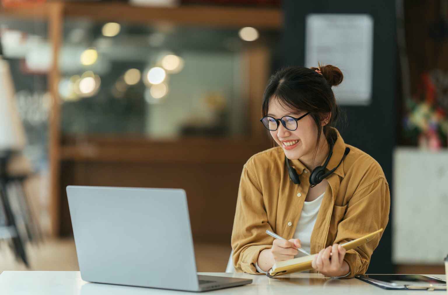 Female student wearing headphones attending an online class