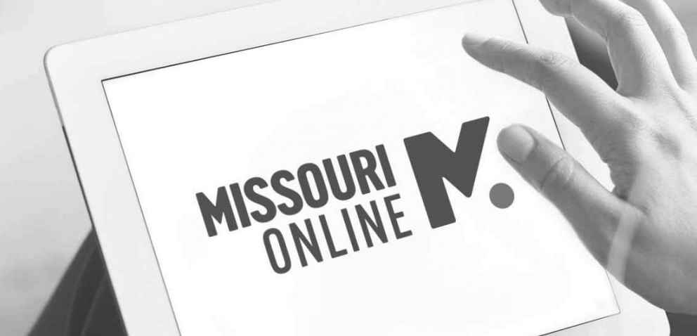 Person's hand on a tablet that displays the Missouri Online logo.
