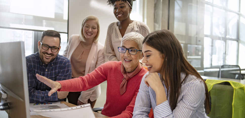 engaged instructor talking to students about something on the computer