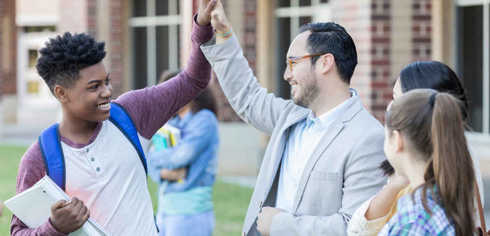 a teacher and student high-five each other