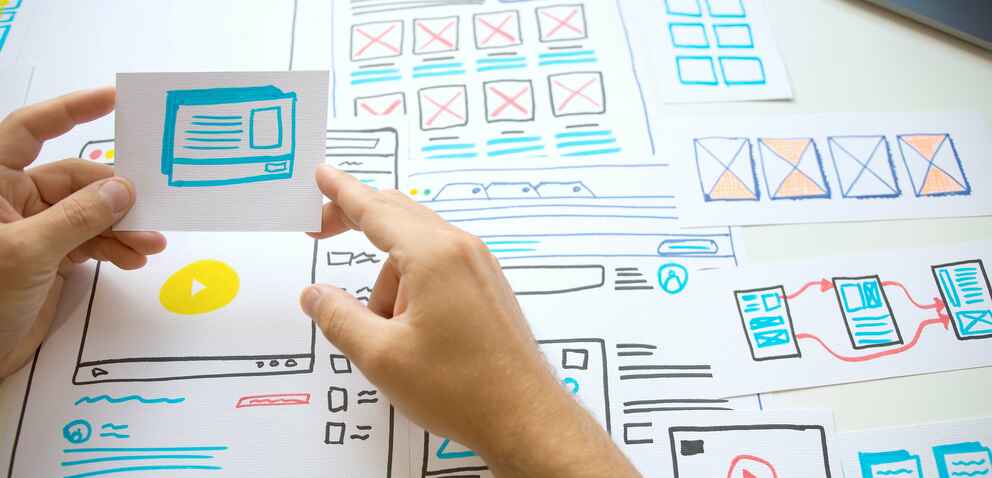 Photo of a person creating a wireframe with pen and paper