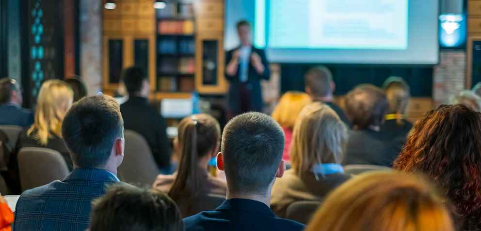 Photo of an audience listening to a speaker