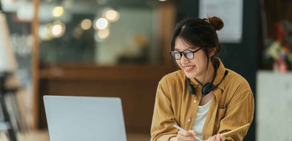 Female student wearing headphones attending an online class