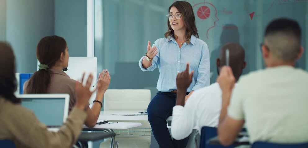 A female professor in a classroom leading a discussion with her students