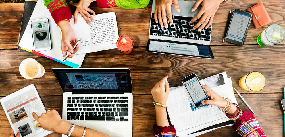 group of people working together using various technology