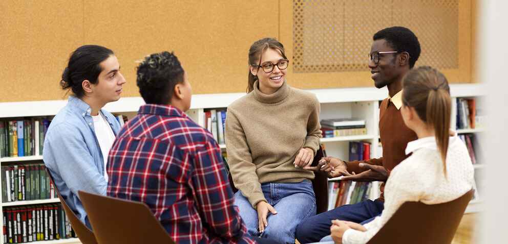 Group of university students sitting in a circle having a group discussion