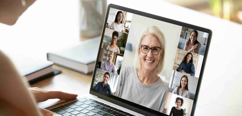 Woman using computer looking at people on screen