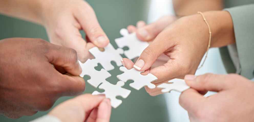 Business people, hands and diversity with puzzle piece for team building, collaboration or planning in unity.