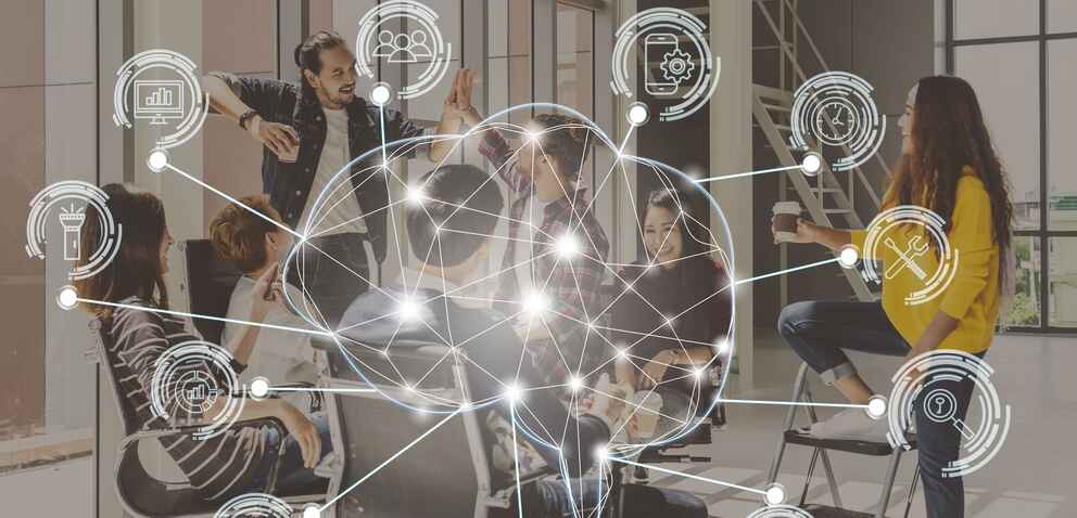 Polygonal brain shape of an artificial intelligence with various icon of smart city Internet of Things over group of diverse Business people are brainstorming and hand shaking.